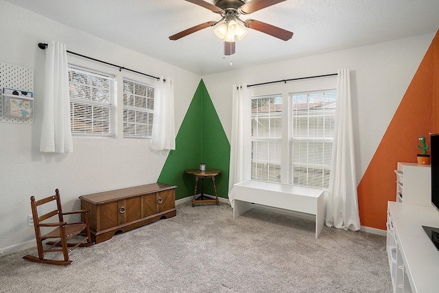 interior space with ceiling fan and light carpet