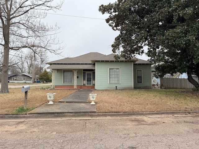 bungalow-style home featuring fence and a front yard