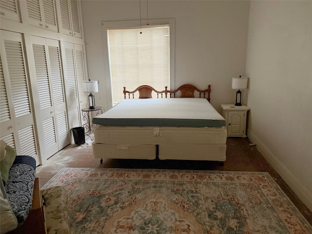 bedroom featuring baseboards and two closets