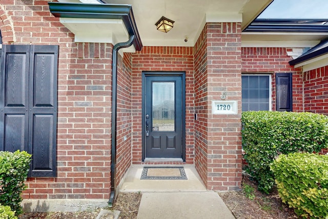 entrance to property featuring brick siding