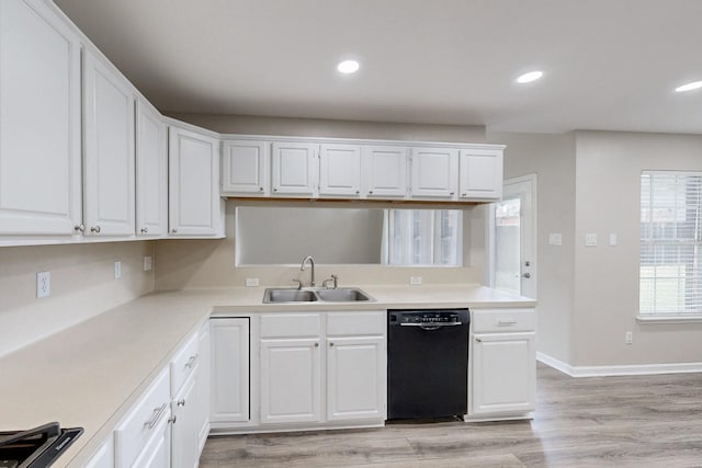 kitchen with white cabinetry, black dishwasher, and sink