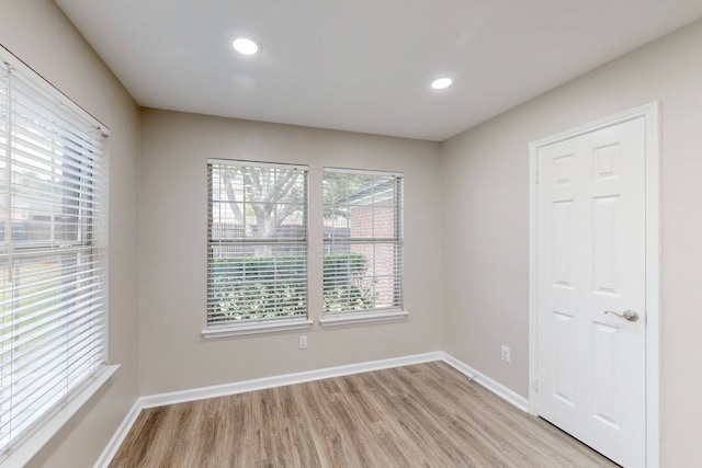 empty room with recessed lighting, light wood-style floors, and baseboards