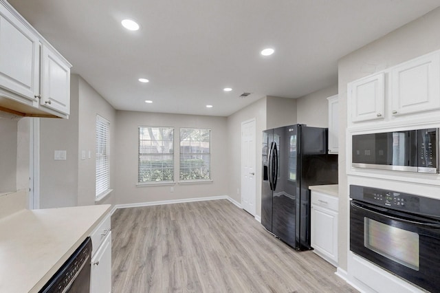 kitchen featuring light wood finished floors, recessed lighting, black appliances, light countertops, and white cabinetry