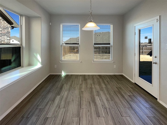 unfurnished dining area with a healthy amount of sunlight and dark hardwood / wood-style flooring