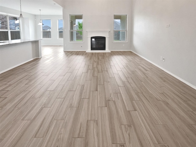6416 Texas Cowboy Dr, Fort Worth, TX 76123 - unfurnished living room featuring wood finished floors, baseboards, and a glass covered fireplace