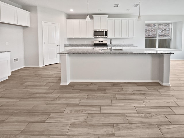 6416 Texas Cowboy Dr, Fort Worth, TX 76123 - kitchen with stainless steel appliances, a sink, white cabinets, an island with sink, and recessed lighting
