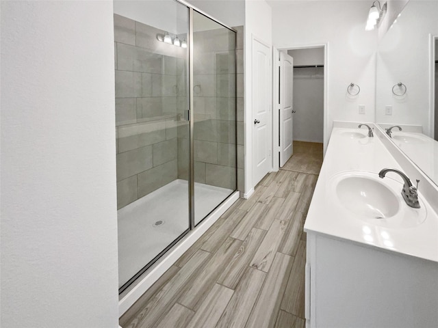6416 Texas Cowboy Dr, Fort Worth, TX 76123 - full bathroom featuring double vanity, a stall shower, wood tiled floors, and a walk in closet