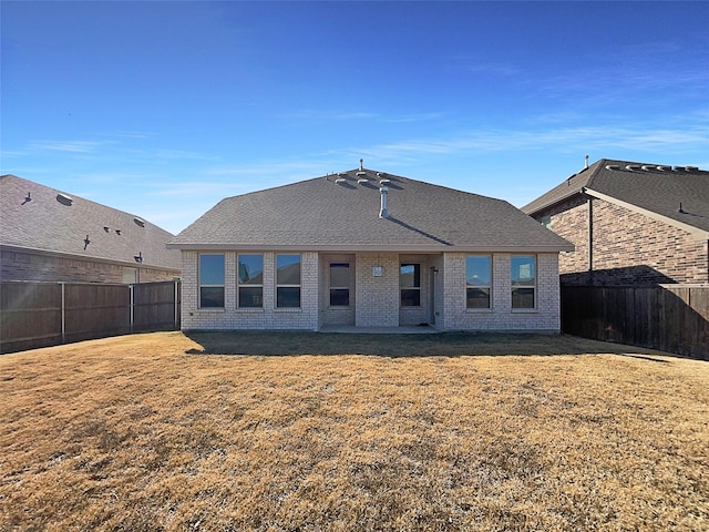 rear view of property featuring a lawn