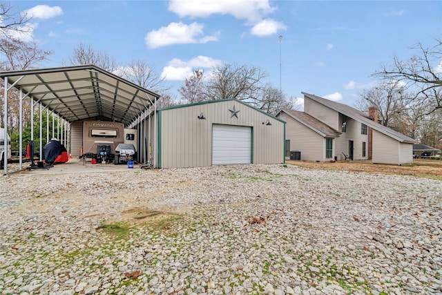 view of outdoor structure with a carport, a garage, and central AC unit