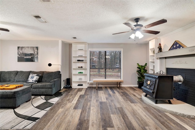 living room with ceiling fan, hardwood / wood-style floors, and a textured ceiling