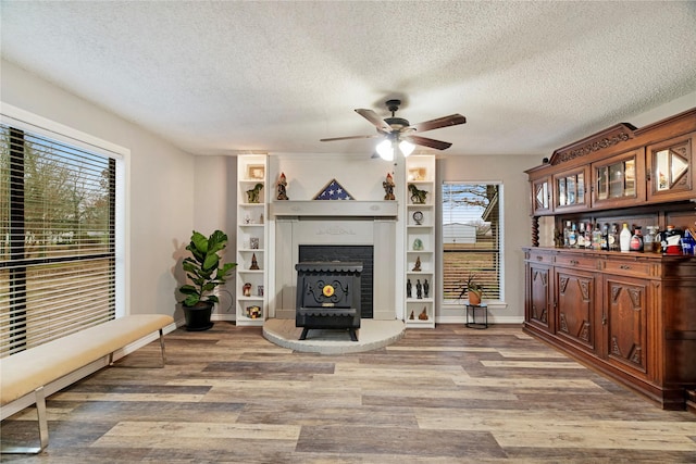 living room featuring hardwood / wood-style flooring, a textured ceiling, and ceiling fan