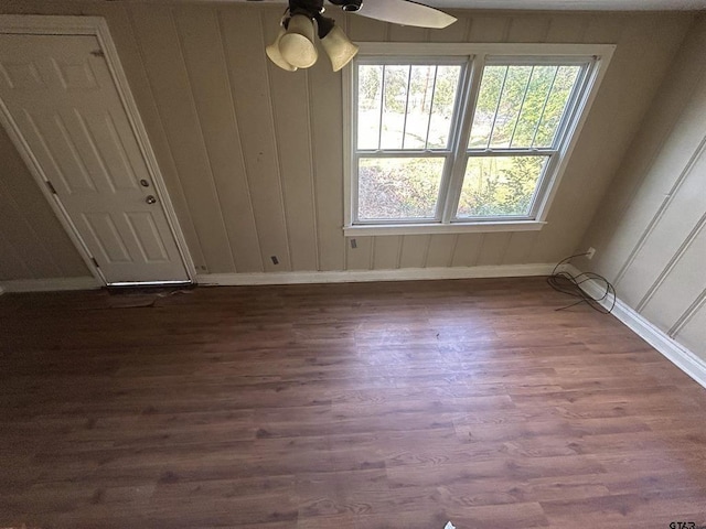 empty room with ceiling fan and dark hardwood / wood-style flooring