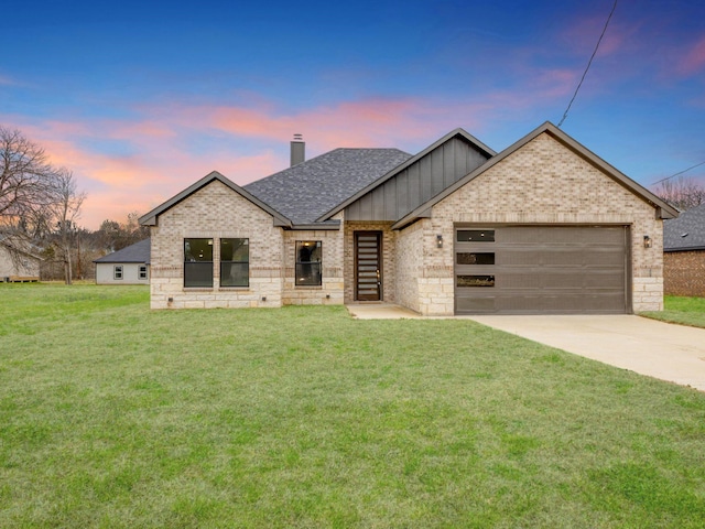 view of front of property featuring concrete driveway, a chimney, an attached garage, a front lawn, and brick siding