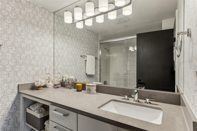 bathroom featuring a shower with door and vanity