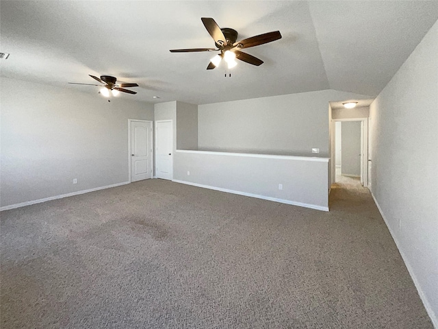 empty room featuring ceiling fan, lofted ceiling, and carpet flooring