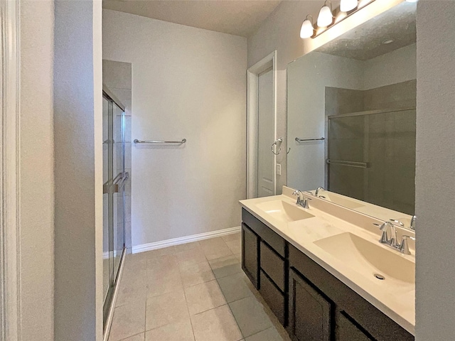 bathroom with tile patterned floors, a shower with door, and vanity