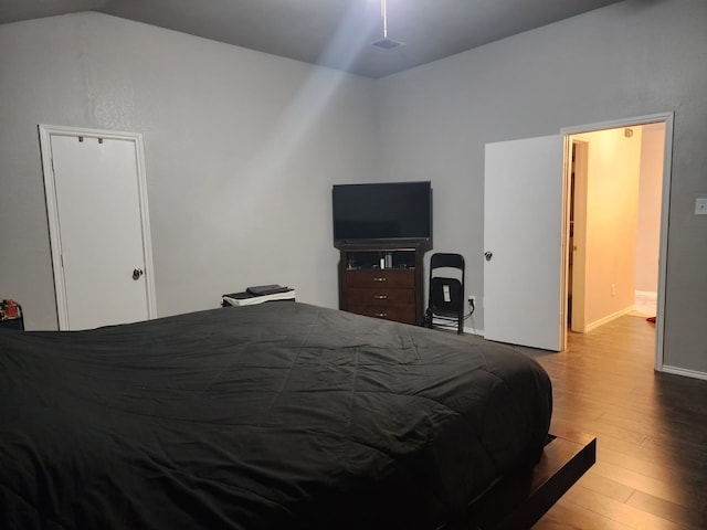 bedroom featuring lofted ceiling and light hardwood / wood-style floors