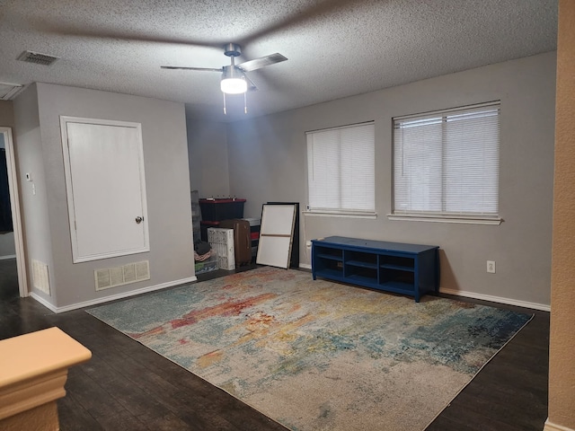 empty room with ceiling fan, a textured ceiling, and dark hardwood / wood-style flooring