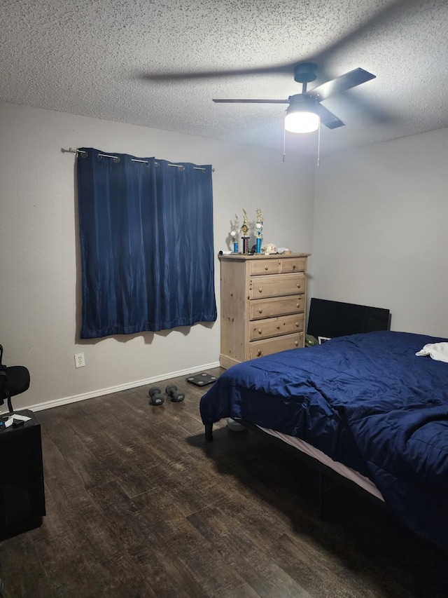 bedroom with dark hardwood / wood-style flooring, ceiling fan, and a textured ceiling