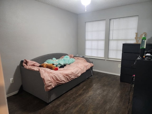 bedroom with dark wood-type flooring and a textured ceiling