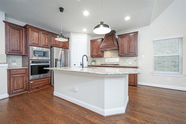 kitchen with custom range hood, dark wood-style flooring, hanging light fixtures, stainless steel appliances, and a sink