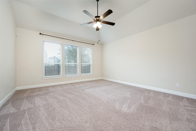 spare room with carpet, vaulted ceiling, baseboards, and ceiling fan