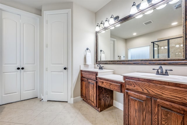 bathroom with double vanity, a shower stall, visible vents, and a sink