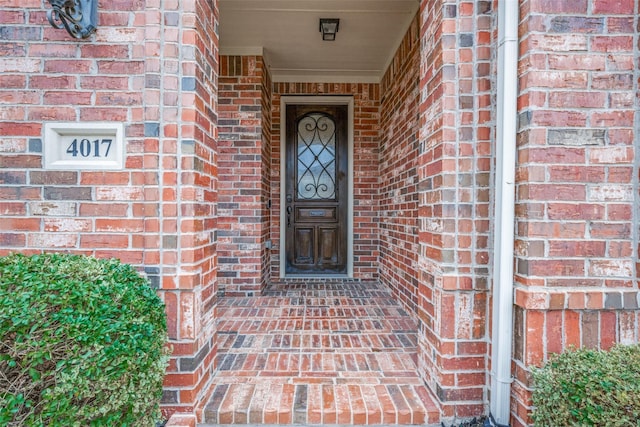 doorway to property featuring brick siding