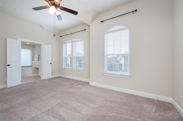 unfurnished bedroom featuring lofted ceiling, baseboards, and light colored carpet