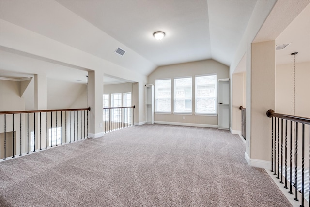 additional living space featuring lofted ceiling, carpet, visible vents, and baseboards