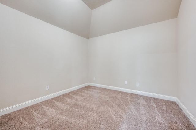 carpeted empty room with lofted ceiling and baseboards