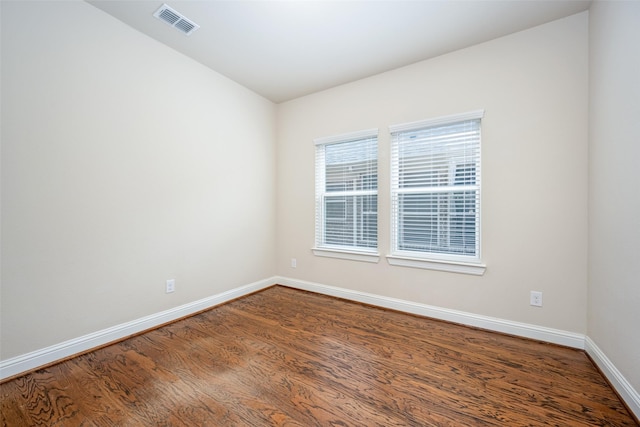 unfurnished room with visible vents, baseboards, and wood finished floors