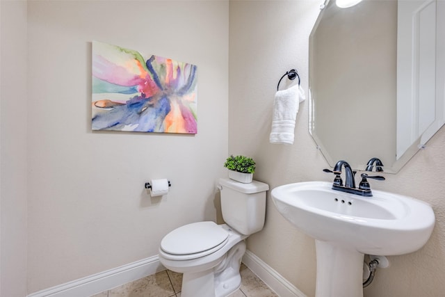 bathroom with tile patterned flooring, baseboards, a sink, and toilet