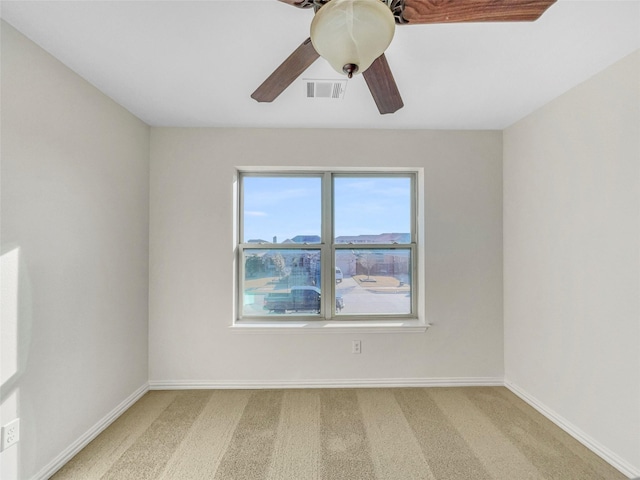 spare room with ceiling fan and carpet