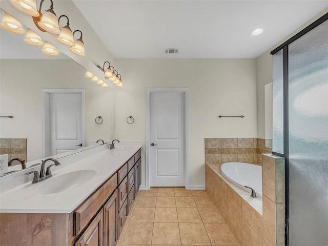 bathroom with vanity, tile patterned floors, and tiled bath