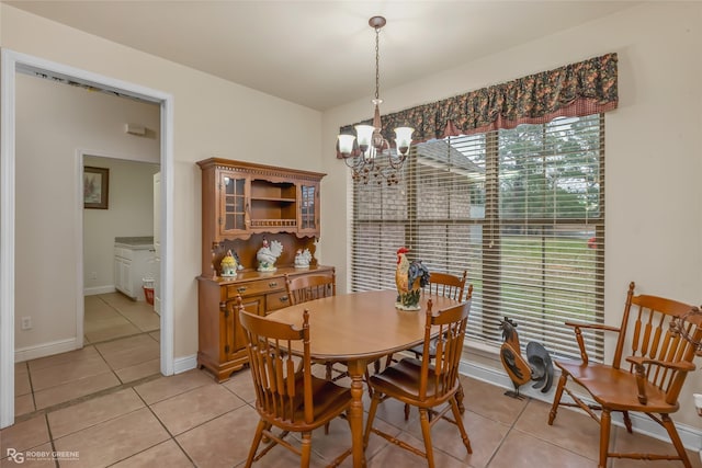 tiled dining room with an inviting chandelier