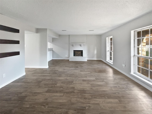 unfurnished living room featuring dark hardwood / wood-style floors and a textured ceiling