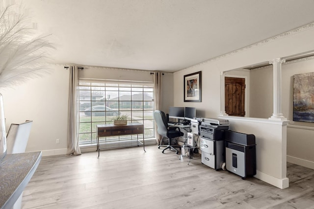 office with light hardwood / wood-style floors and ornate columns