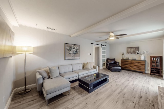 living room featuring ceiling fan, a barn door, light hardwood / wood-style floors, and beam ceiling