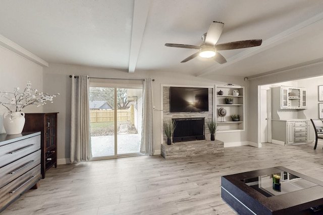 living room featuring beamed ceiling, ceiling fan, hardwood / wood-style floors, and a fireplace