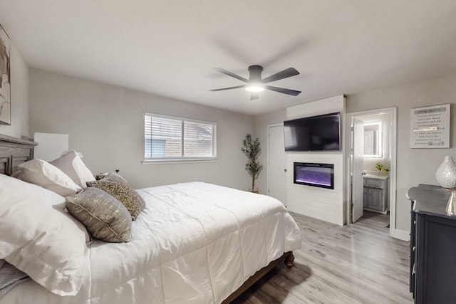 bedroom featuring hardwood / wood-style flooring, ceiling fan, and connected bathroom