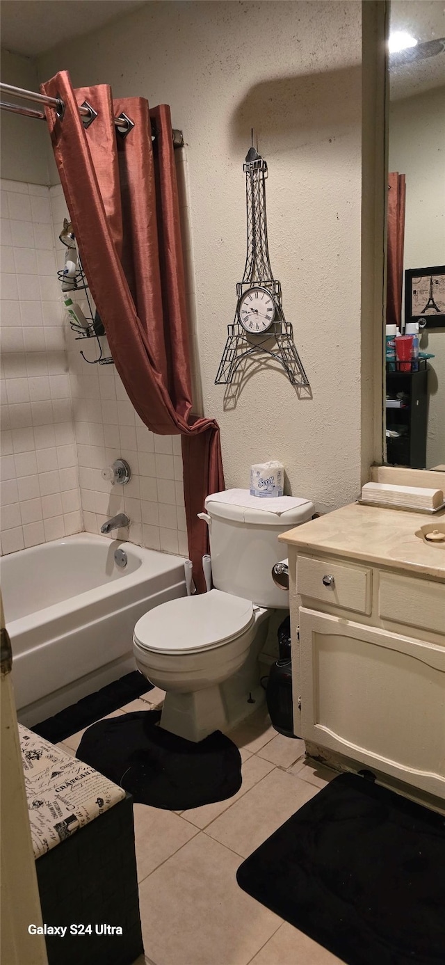 full bathroom with tiled shower / bath, tile patterned floors, toilet, and vanity