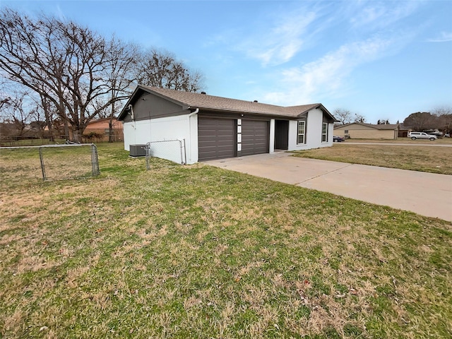 view of front of property featuring cooling unit, a garage, and a front yard