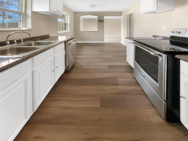 kitchen with dark hardwood / wood-style flooring, sink, white cabinets, and appliances with stainless steel finishes