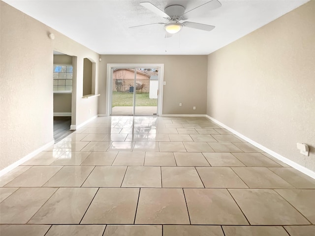 tiled spare room with ceiling fan