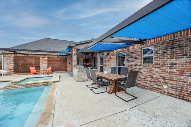 view of patio / terrace featuring a swimming pool with hot tub and exterior kitchen