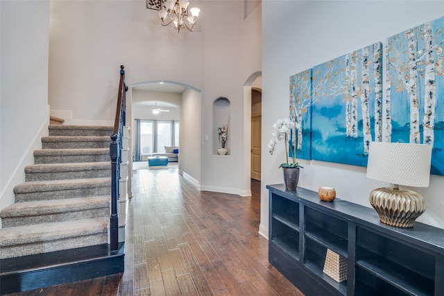 entryway featuring dark hardwood / wood-style floors, a chandelier, and a towering ceiling