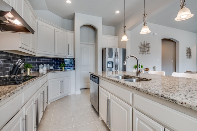 kitchen with white cabinetry, sink, hanging light fixtures, stainless steel appliances, and wall chimney range hood