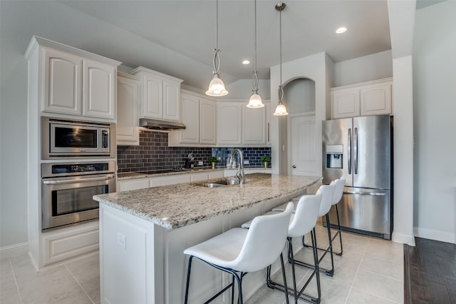 kitchen with light stone countertops, white cabinetry, appliances with stainless steel finishes, and sink