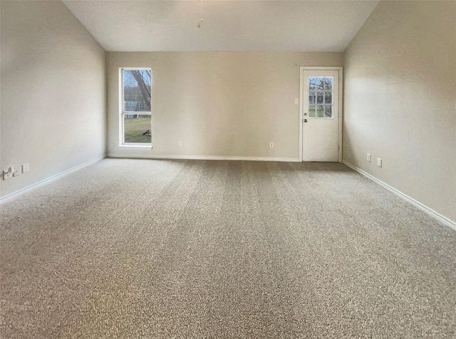 empty room featuring carpet floors and vaulted ceiling